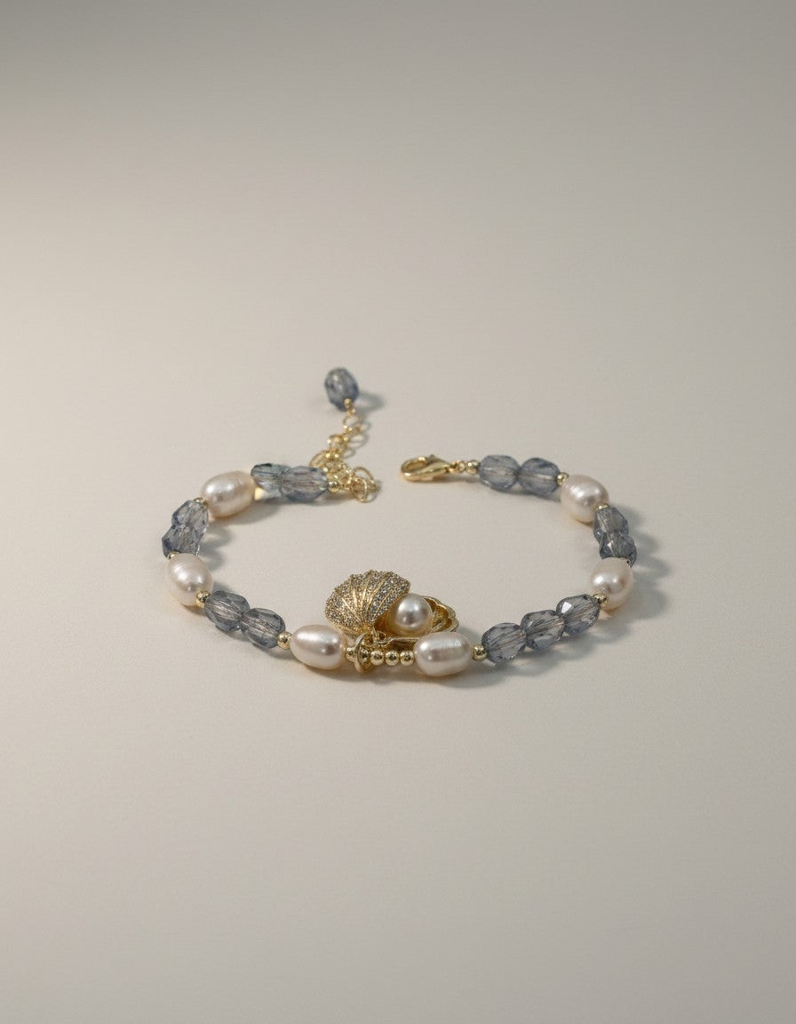 MuchiPearl and crystal beaded bracelet with seashell charm and cubic zirconia accents. Gold-tone adjustable chain.