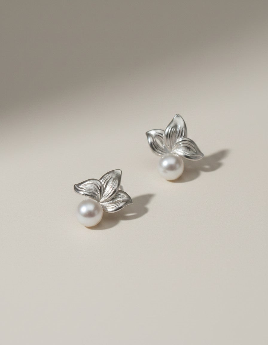 Muchier silver leaf and pearl stud earrings with intricate floral detailing and lustrous freshwater pearls.