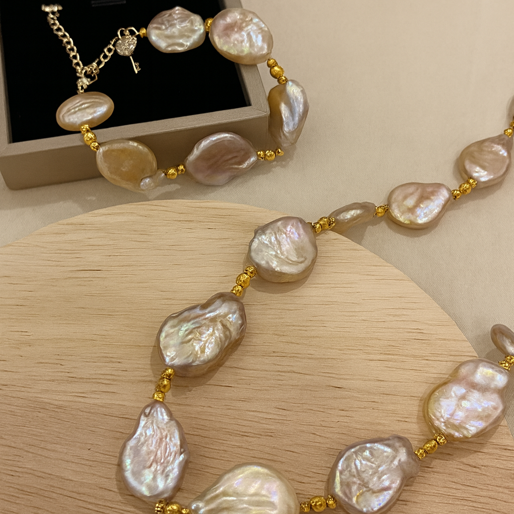 Pearl necklace with gold accents on a wooden surface