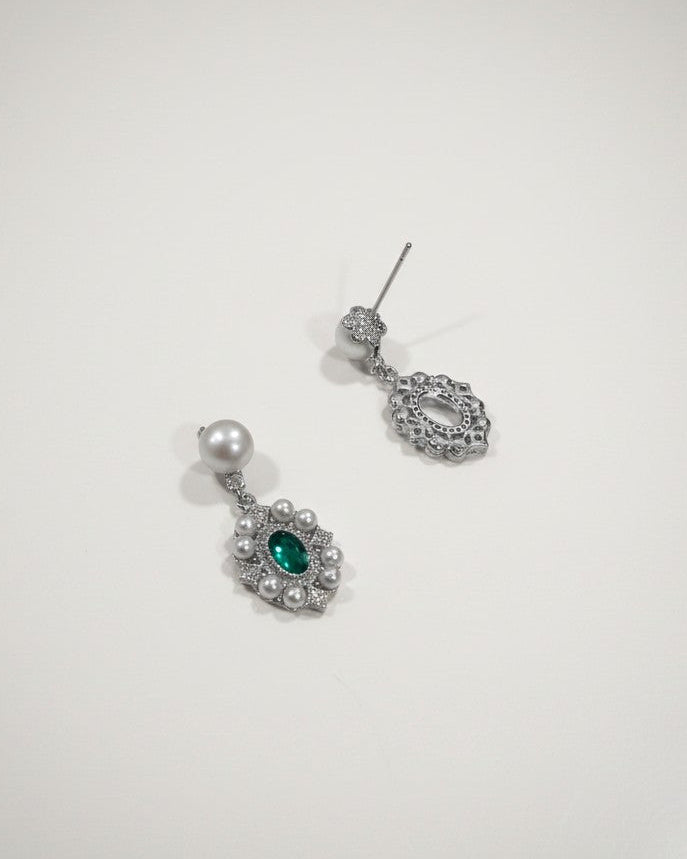 Pair of silver earrings with green gemstones on a white background