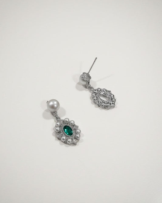 Pair of silver earrings with green gemstones on a white background