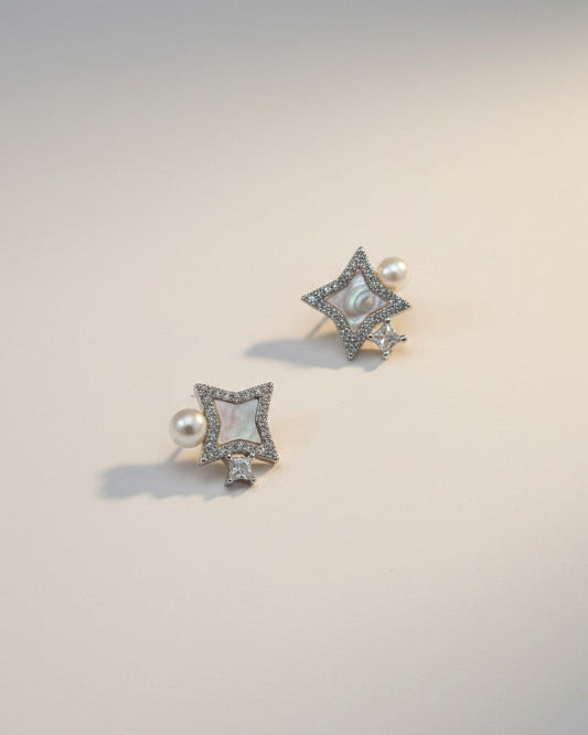Pair of square-shaped earrings with pearls on a light gray background