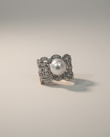 Silver ring with a pearl on a gray background