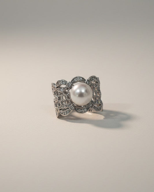 Silver ring with a pearl on a gray background