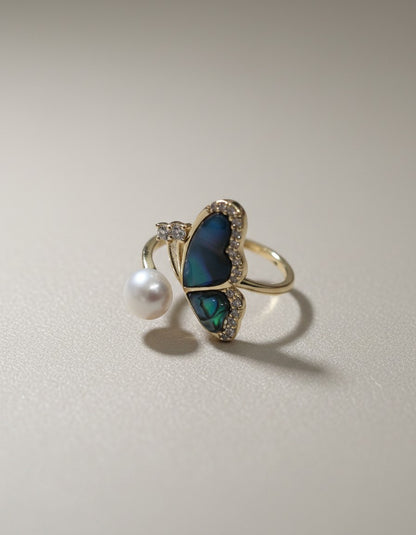Muchi Butterfly ring with abalone inlay, pearl, and cubic zirconia accents. Adjustable gold-tone band.