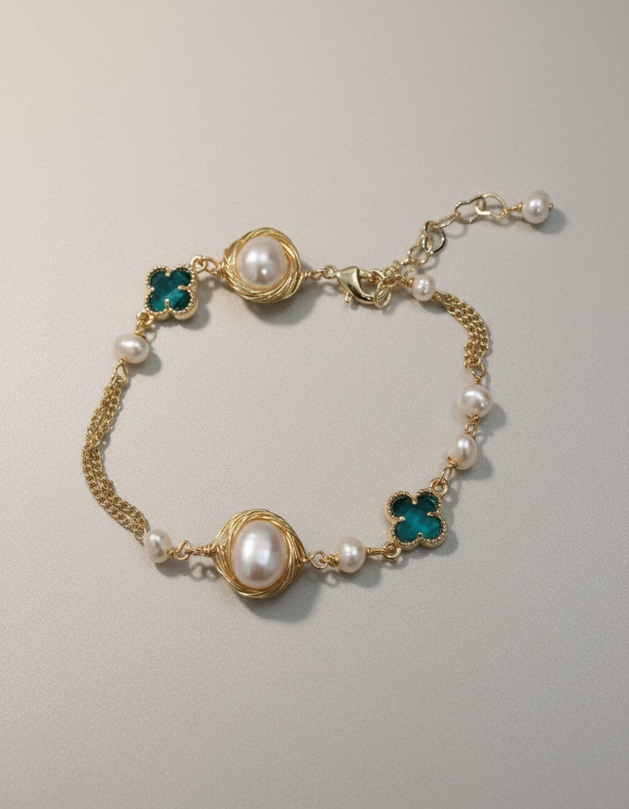 MuchiGold tone chain bracelet with freshwater pearls and emerald green clover charms, adjustable clasp.