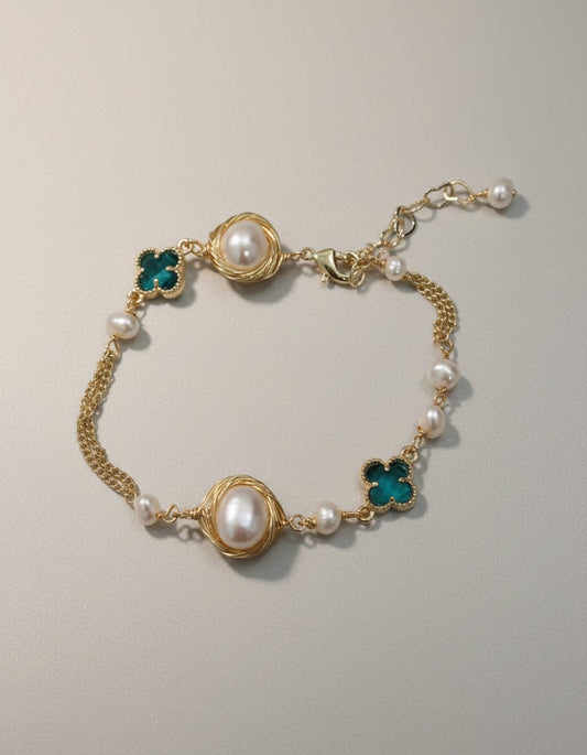 MuchiGold tone chain bracelet with freshwater pearls and emerald green clover charms, adjustable clasp.