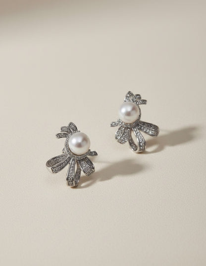 MuchiPearl and crystal bow stud earrings with sterling silver, cubic zirconia, and pearl center. Elegant and whimsical design.