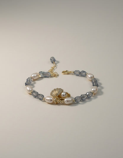MuchiPearl and crystal beaded bracelet with seashell charm and cubic zirconia accents. Gold-tone adjustable chain.