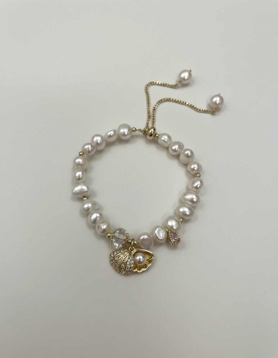 Muchic Adjustable freshwater pearl bracelet with gold-tone chain, seashell charm, and pink gemstone accent.