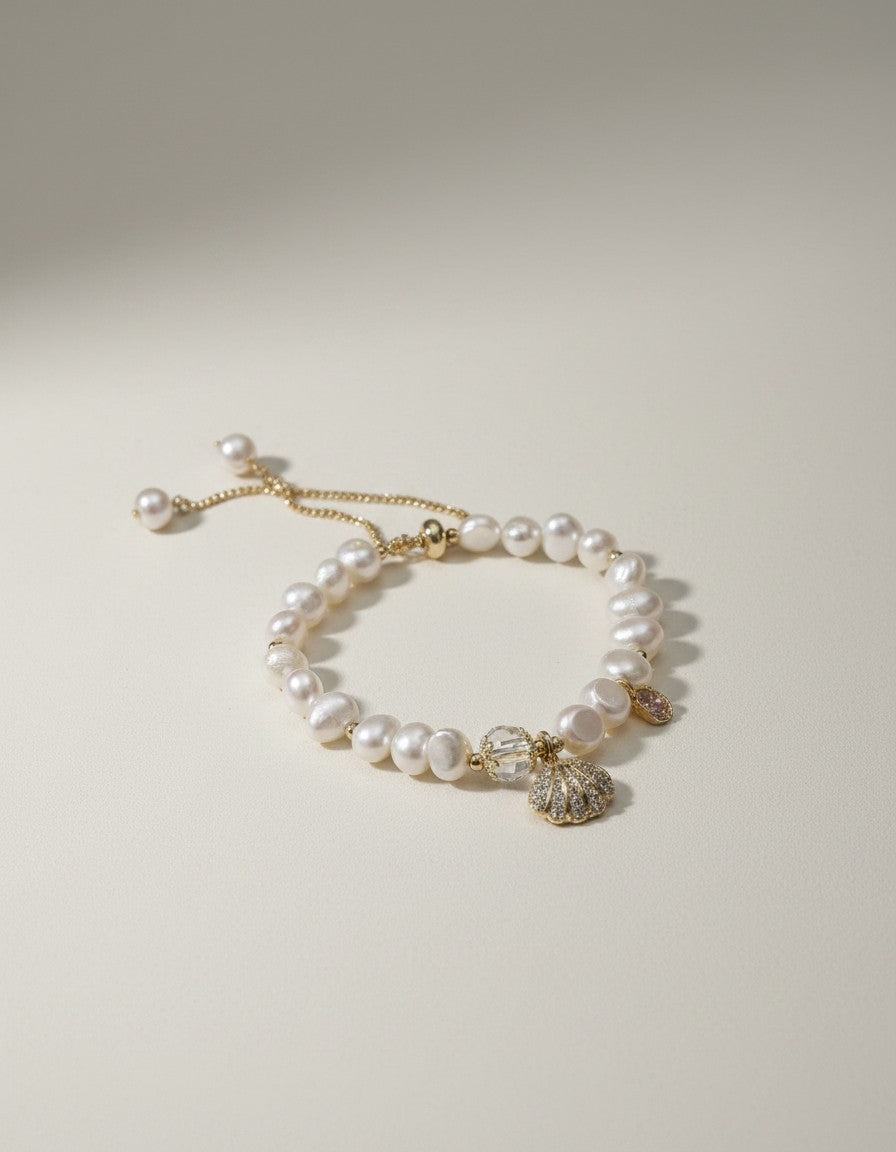 Muchic adjustable bracelet with irregular freshwater pearls, gold-tone chain, seashell charm, and crystal accents.