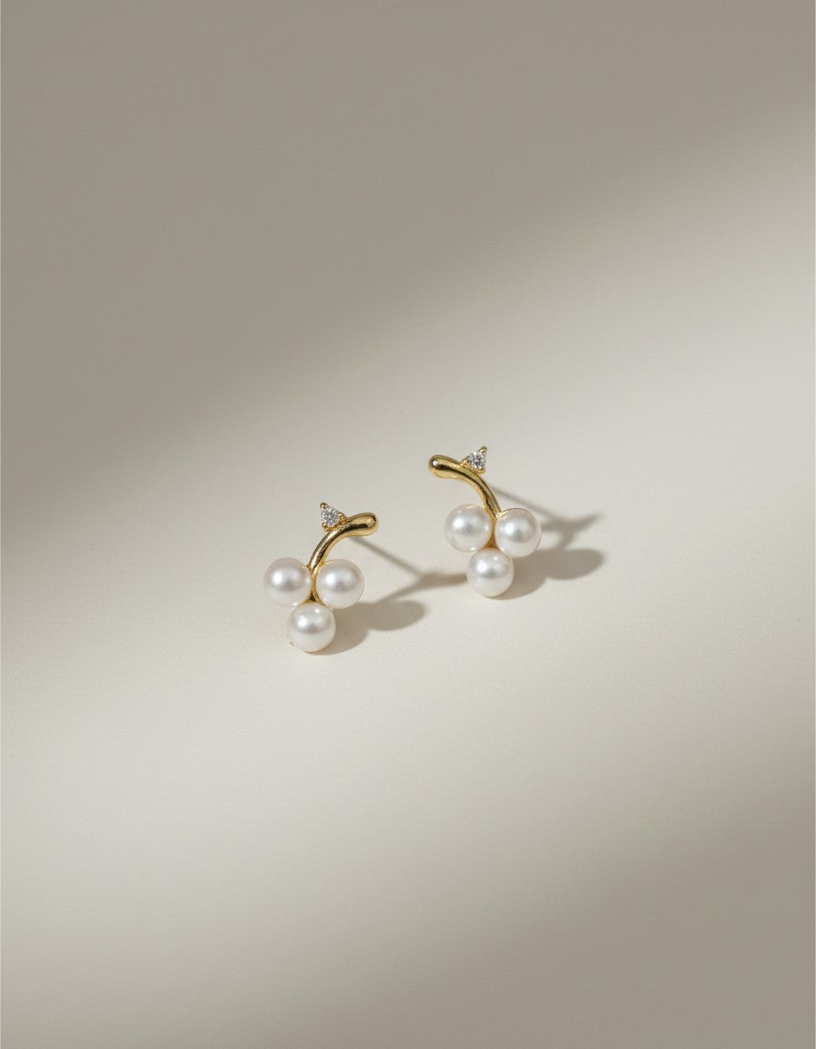 Muchic 14k gold stud earrings with three freshwater pearls and diamond accents, designed as a cherry cluster.
