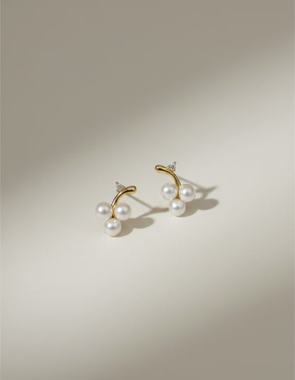 Muchic 14k gold stud earrings with three freshwater pearls and diamond accents, designed as a cherry cluster.