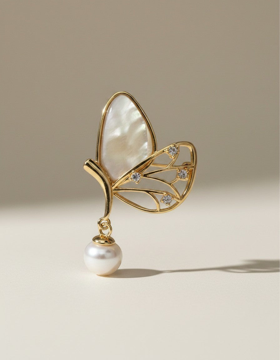 Muchichere gold butterfly brooch with pearl accent and mother-of-pearl inlay wing.