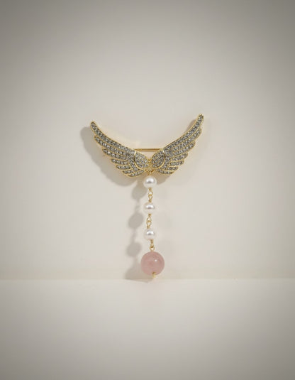 Muchie Angel wing brooch with pearls and rose quartz pendant, adorned with cubic zirconia stones.