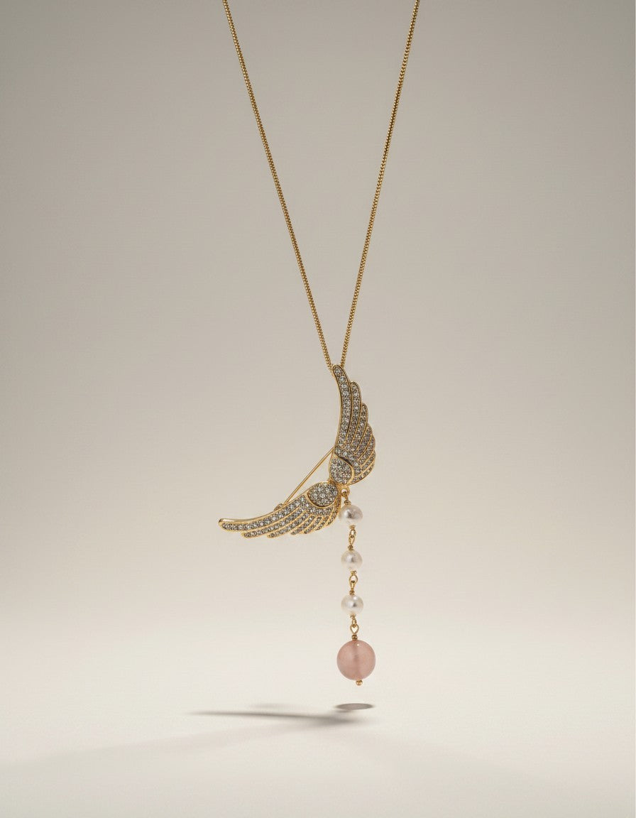 Muchier gold-tone angel wing brooch with cubic zirconia, pearls, and rose quartz pendant.