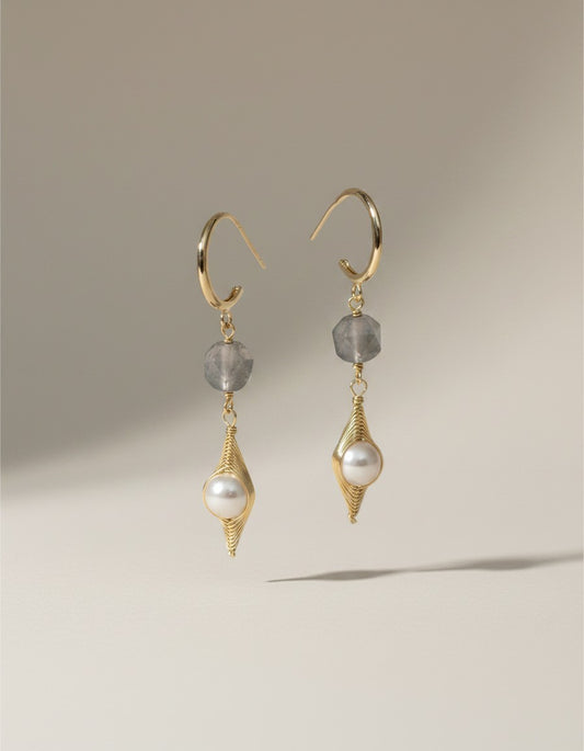 Muchier gold hoop earrings with pearl and grey gemstone accents, featuring a pearl in a wire cage and a faceted grey stone.