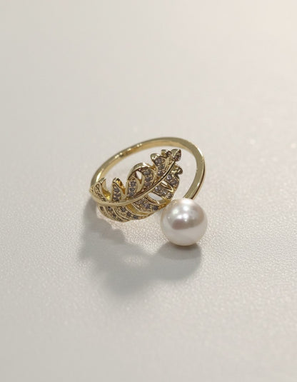 Muchier gold-tone adjustable ring with feather motif and pave cubic zirconia accents, featuring a dangling faux pearl.