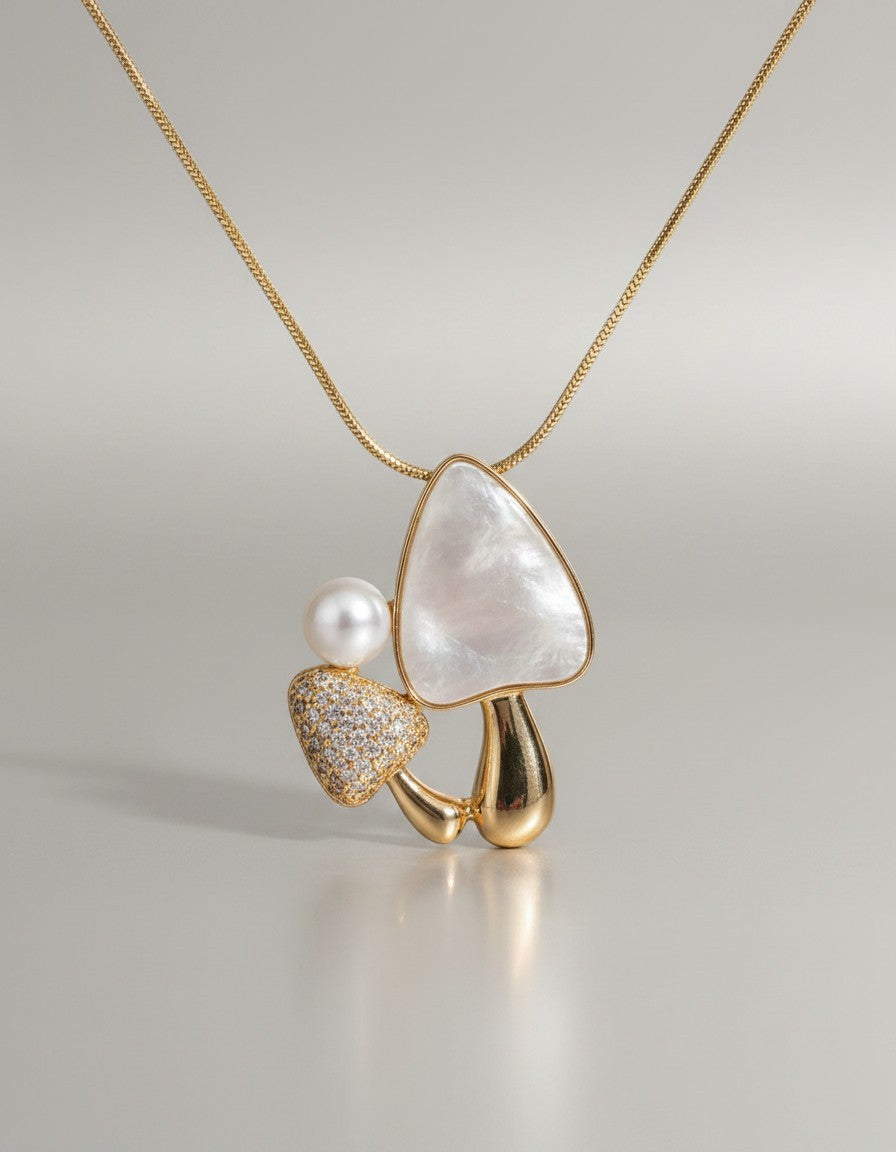 Muchier gold-tone necklace with a mushroom pendant featuring a mother-of-pearl cap and cubic zirconia accents.