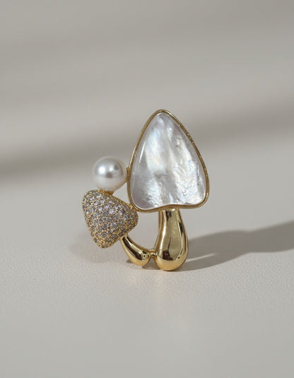 Muchiermushrooms pendant necklace with mother-of-pearl, pearl, and cubic zirconia on gold-tone metal.
