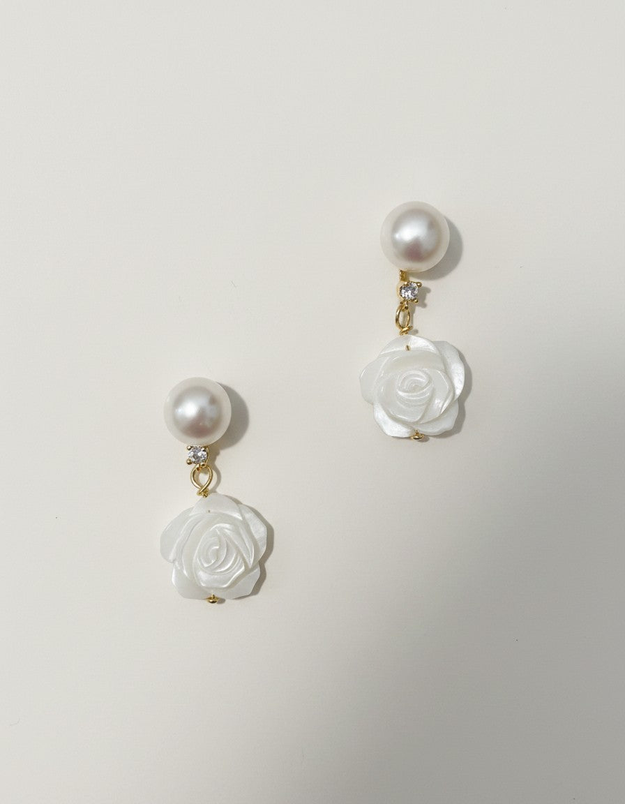 Muchier pearl and carved rose mother of pearl dangle earrings with cubic zirconia accent.