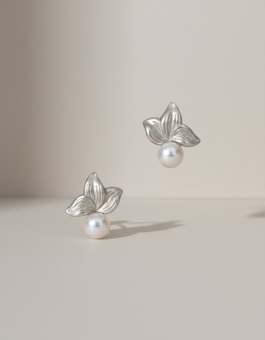 Muchier silver leaf and pearl stud earrings with intricate floral detailing and lustrous freshwater pearls.