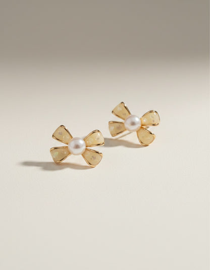 MuchiHere bow-shaped stud earrings with faux pearls and creamy yellow enamel. Gold-tone metal.